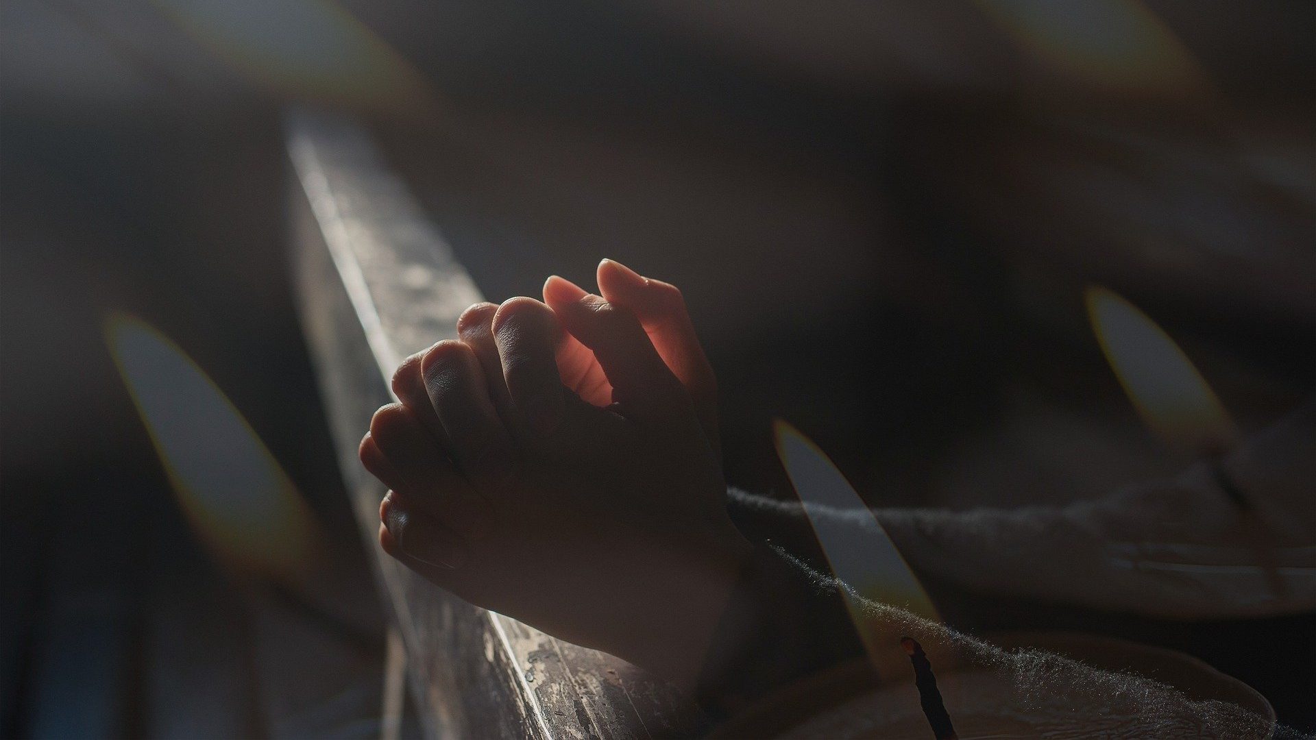 Hände zum Gebet gefaltet in einer Kirche