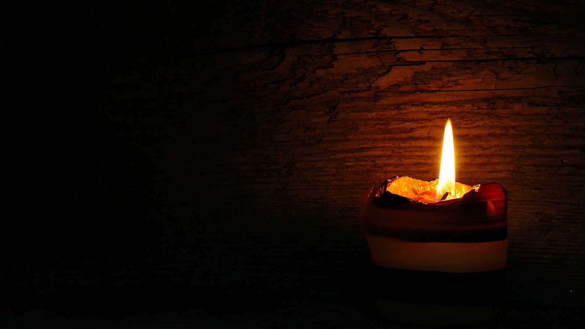 Brennende Kerze in der Dunkelheit